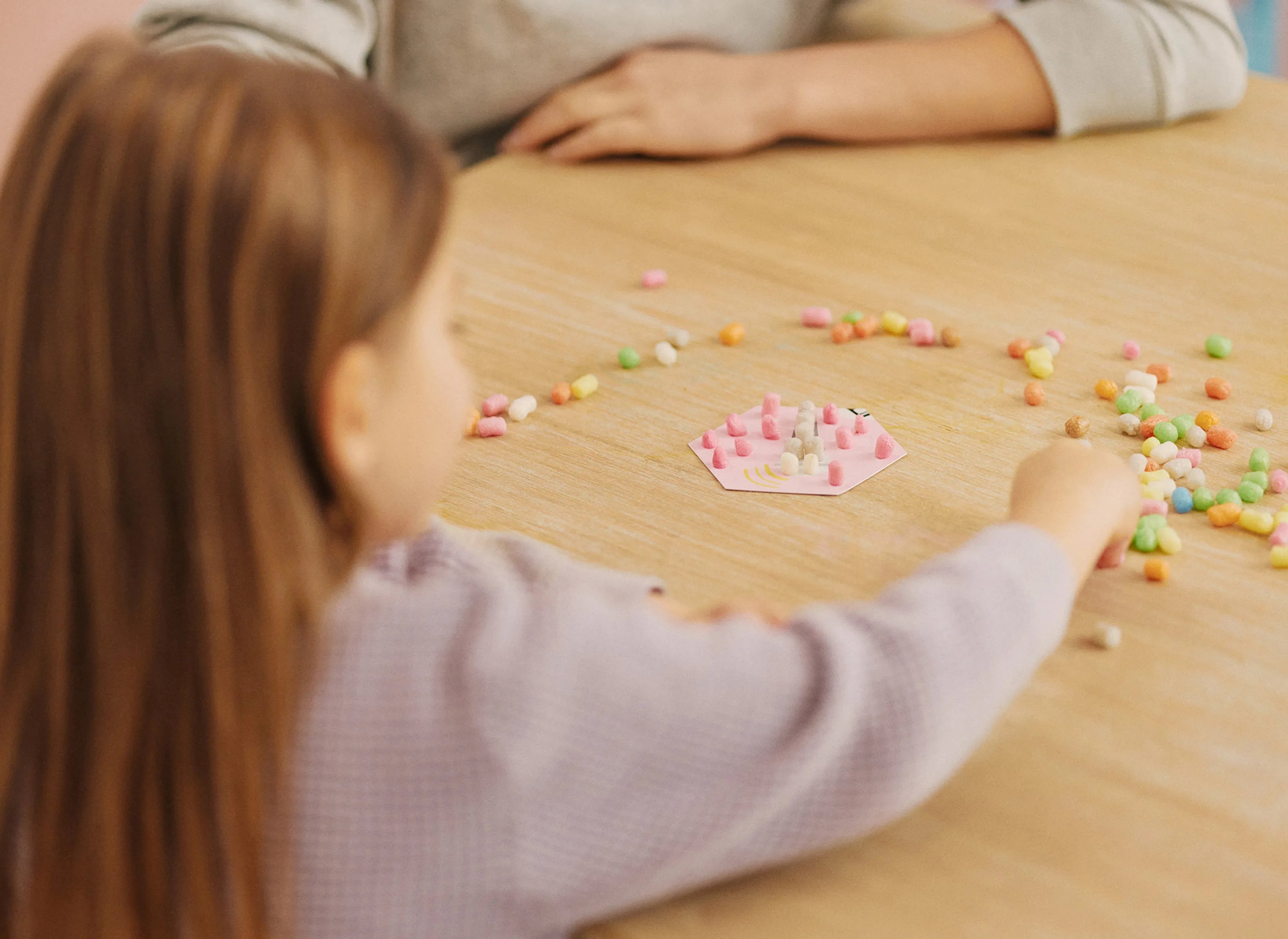 Kind spielt mit bunten Nubsis auf einem Tisch.