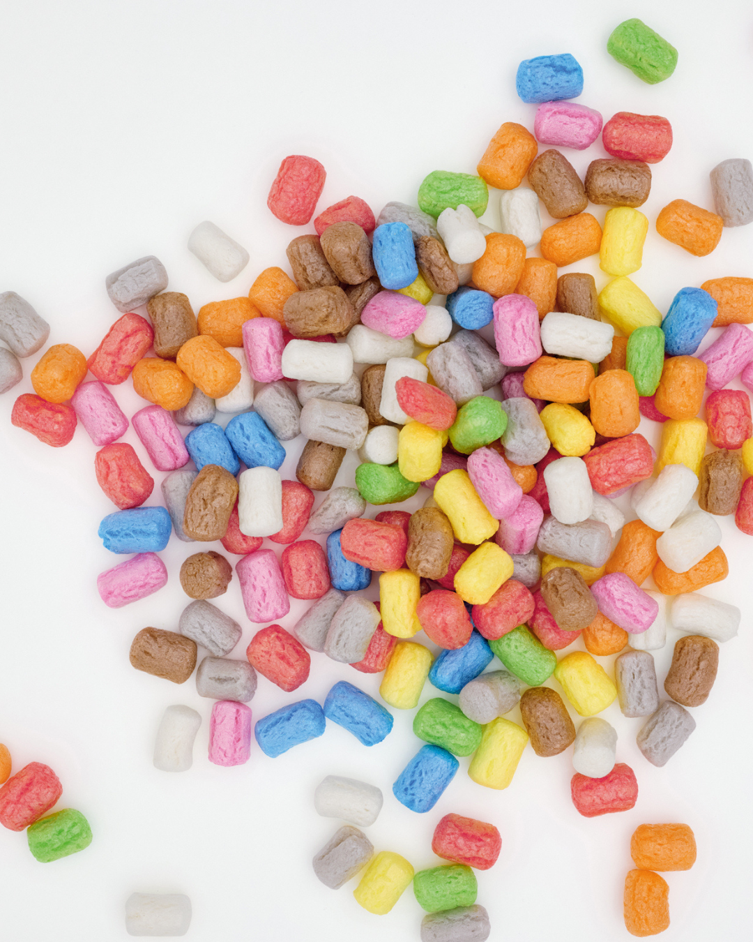 Bunte Nubsis in verschiedenen Farben liegen verstreut auf einer weißen Oberfläche.
