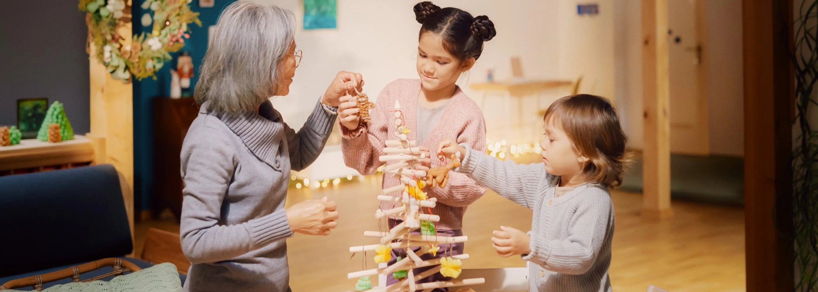 Kinder und Oma schmücken mit Playmais-Deko den Weihnachtsbaum