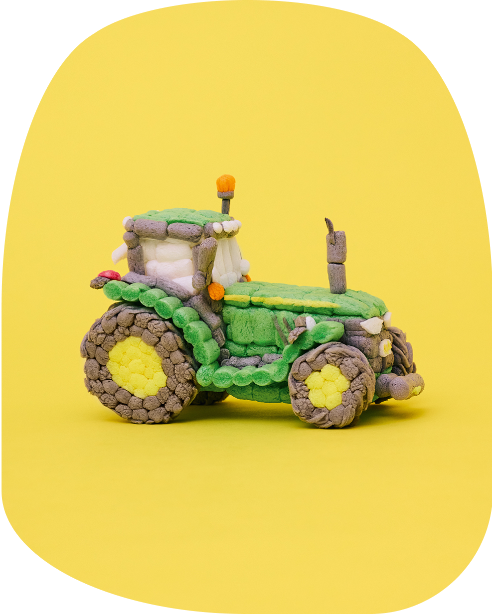 Traktor aus Playmais Classic-Teilen, hauptsächlich in den Farben Grün, Gelb, Braun.