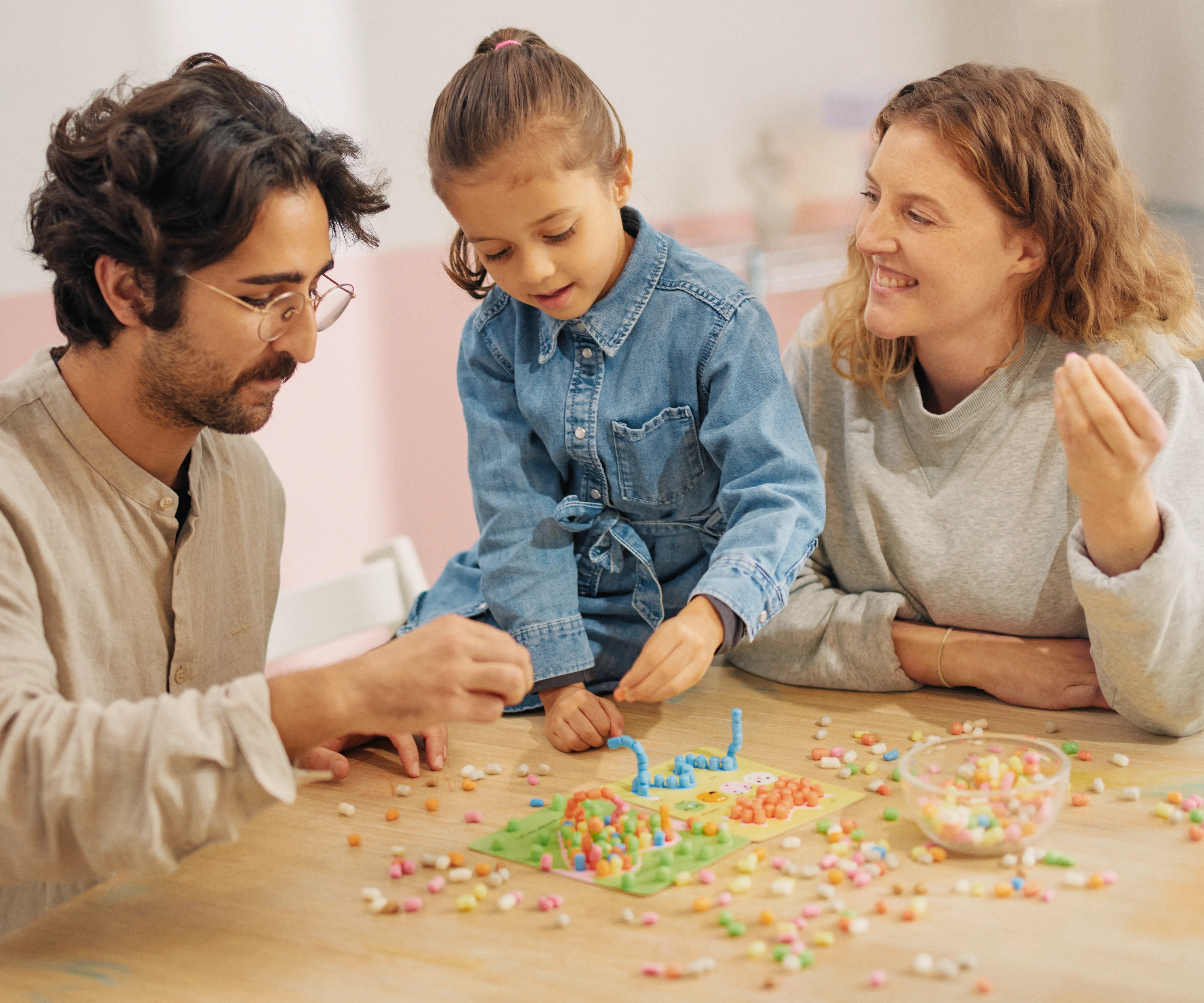Familie sitzt am Tisch und bastelt Playmais Mosaic Affirmation.